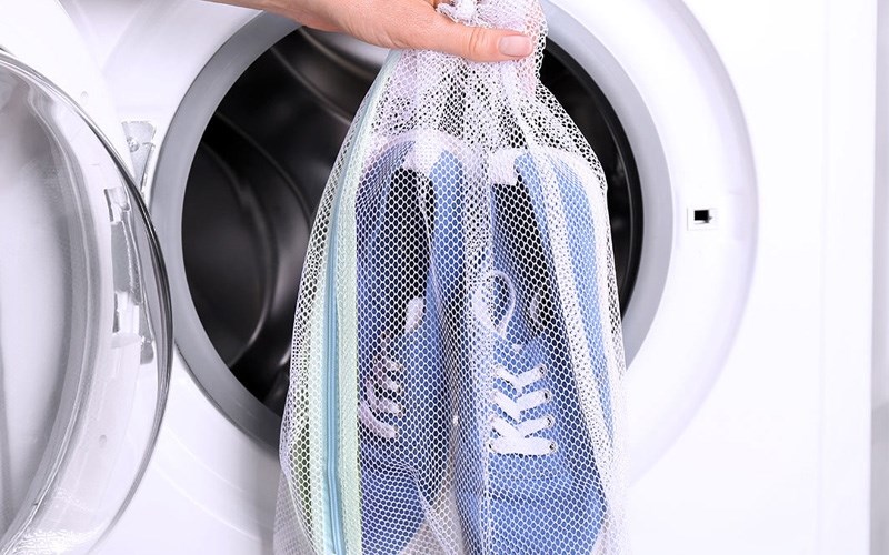 انداختن کفش ها درون کیسه و داخل ماشین لباسشویی