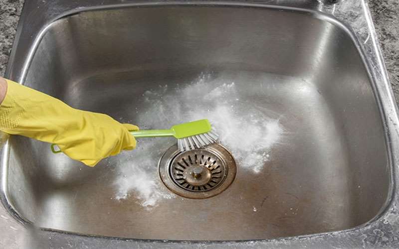 تمیز کردن سینک ظرفشویی با استفاده از مایع ظرفشویی و مسواک